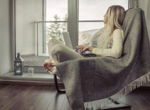Woman relaxing on chair, looking out living room window