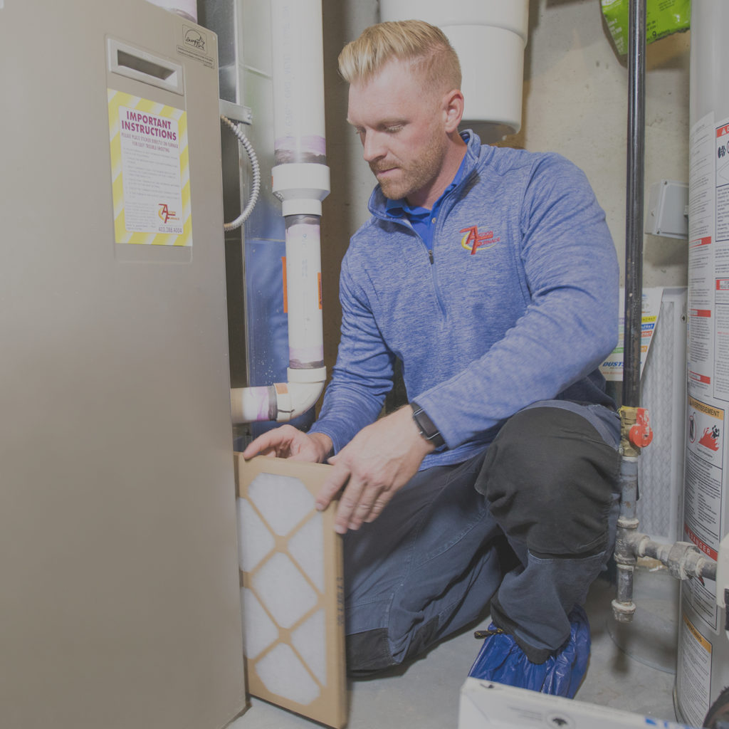 Technician replacing furnace filter.