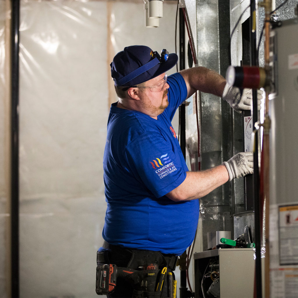 Technician installing furnace filter.