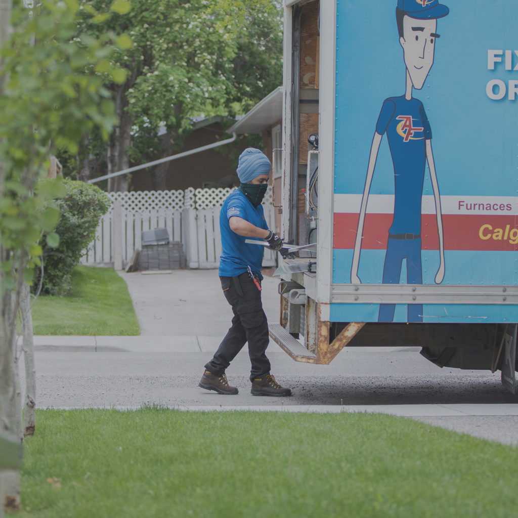 Technician unloading equipment from Action Furnace truck.