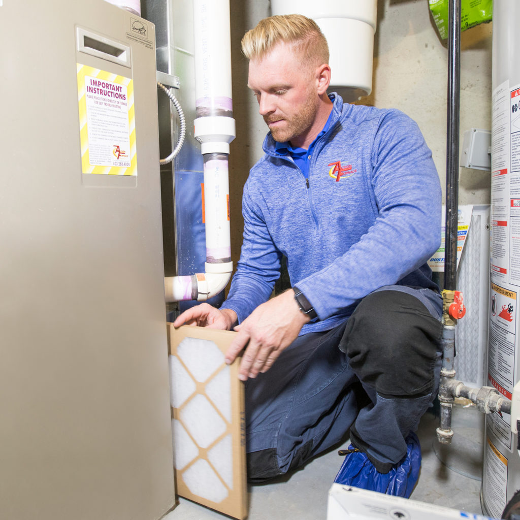 Technician replaces furnace filter.