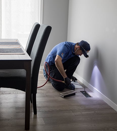 Technician inspecting duct inside home