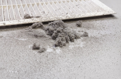 Dust from duct cleaning lying beside air vent