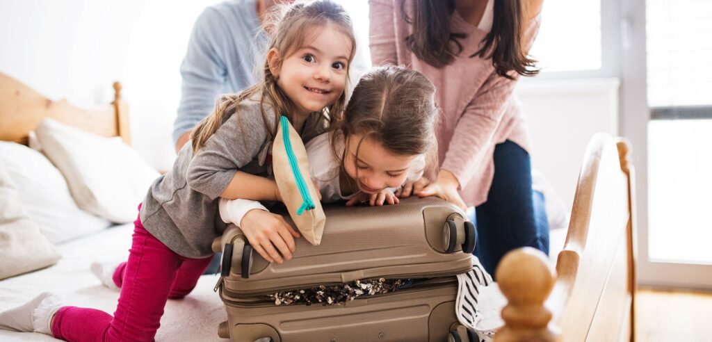 Young kids packing suitcase.