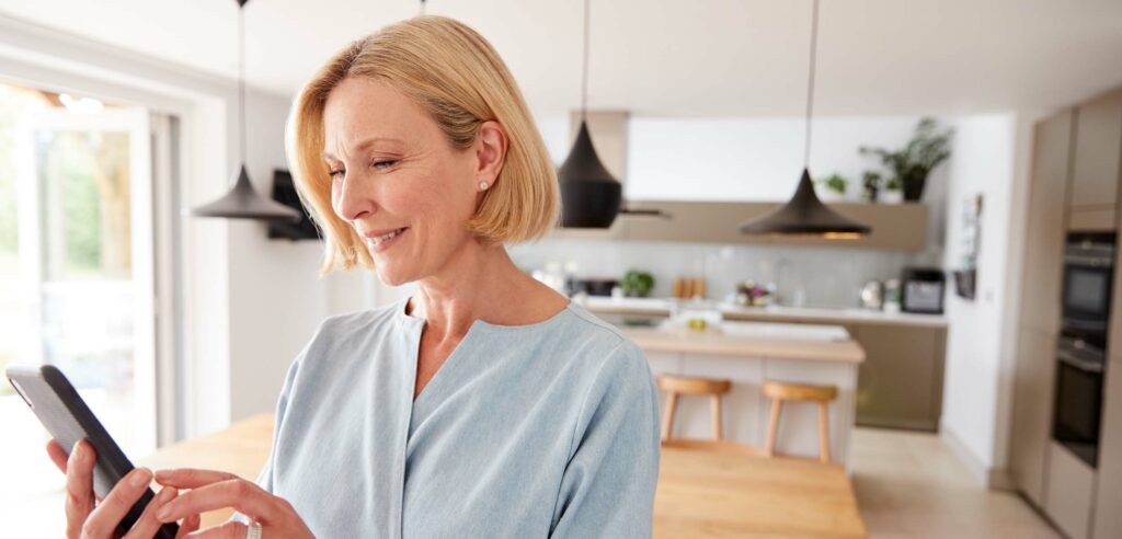 Woman smiling looking at her smart phone.