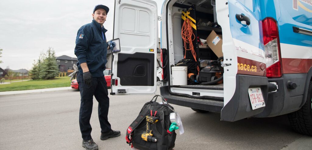 Action Furnace tech smiling while unloading his van outside customers home.