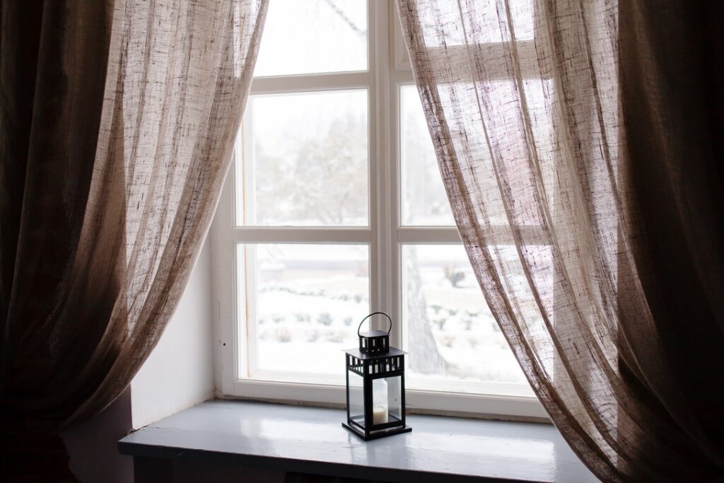 Open curtains letting in sunlight during winter to help heat home