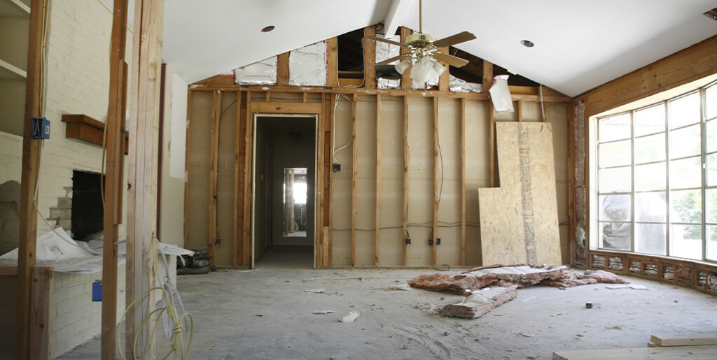 Living room partially demolished, revealing studs on one wall.