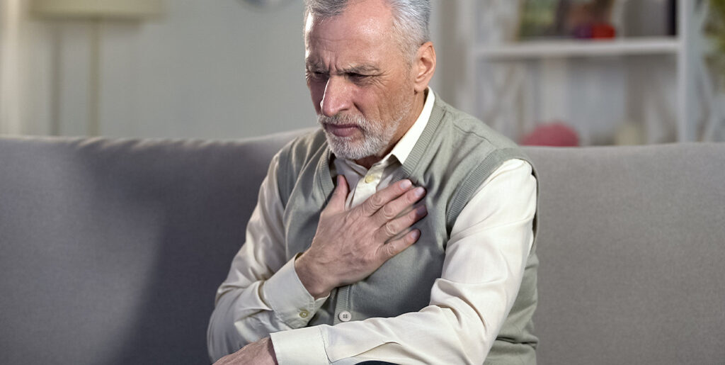Man holding chest struggling to breathe