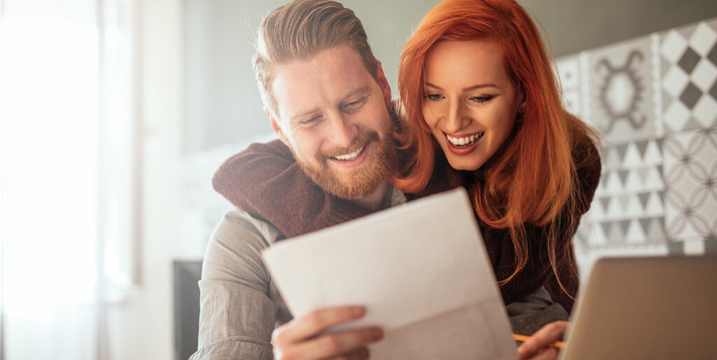 Couple happy looking at the bill for their new High-Efficiency Furnace
