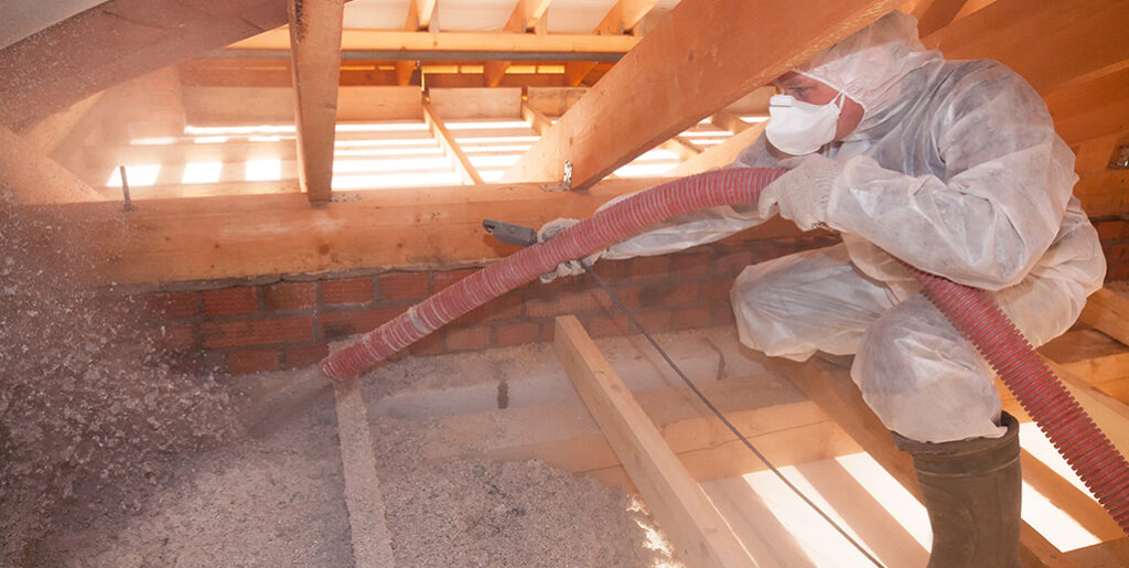 Technician installing spray insulation.
