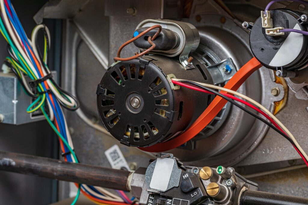 Inside view of natural gas furnace with blower motor visible to symbolize noise reduction from new high-efficiency models