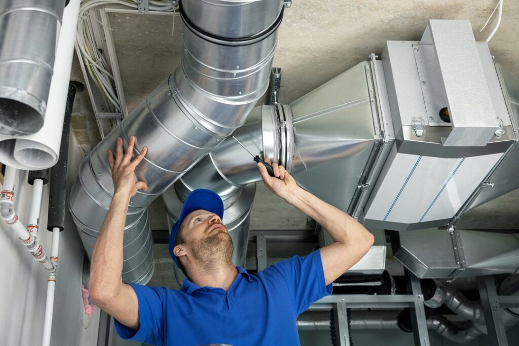 Technician inspects seals on ductwork.