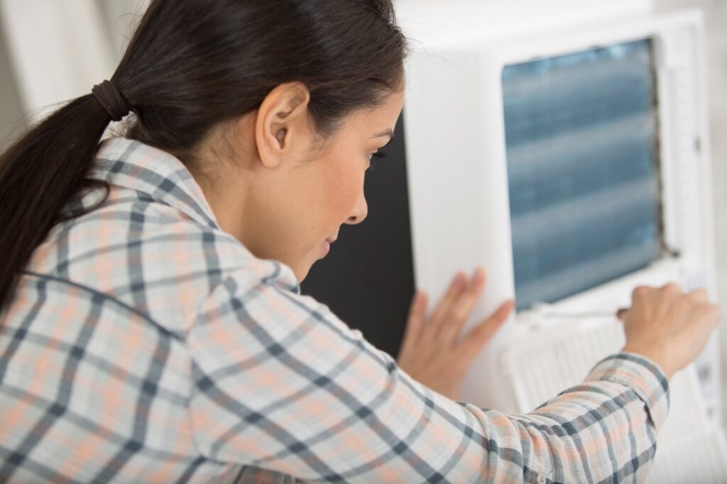 a young woman cleaning air conditioning system