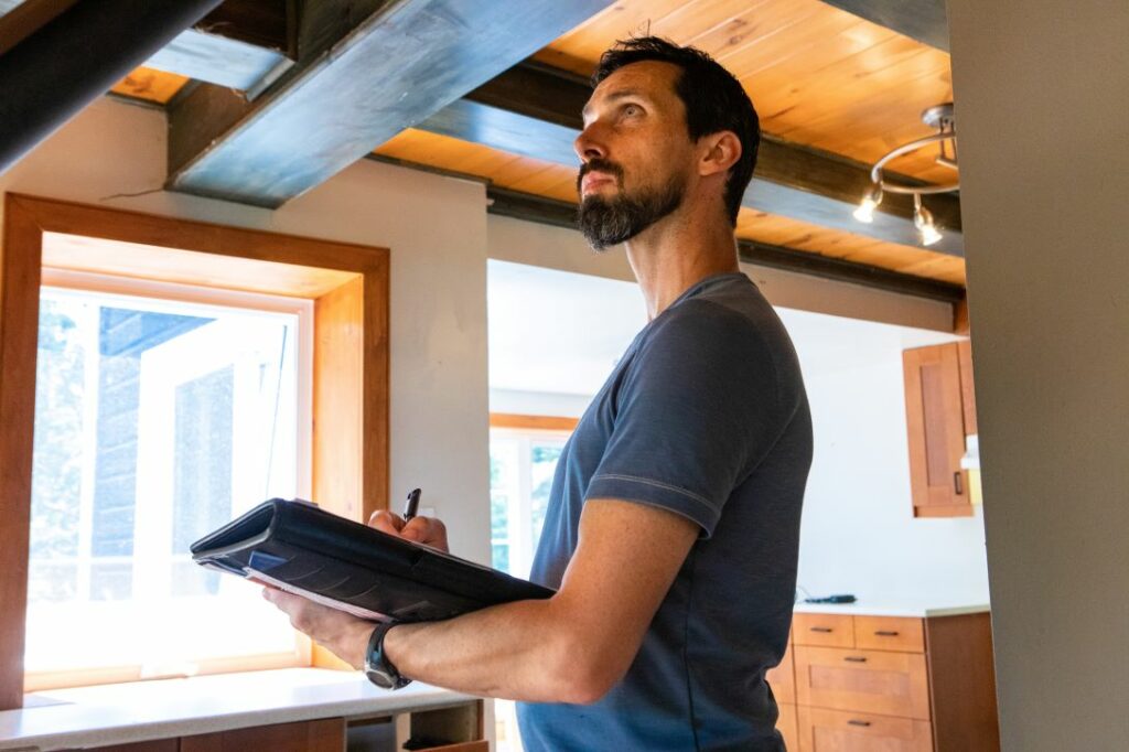 Man with binder assessing home