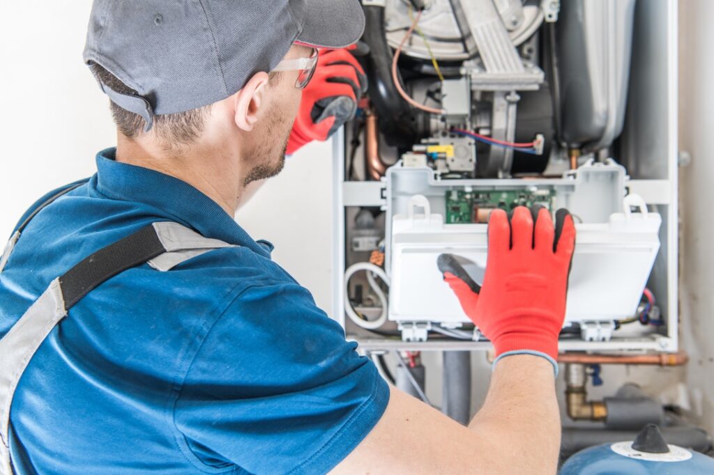 Professional providing maintenance to home furnace