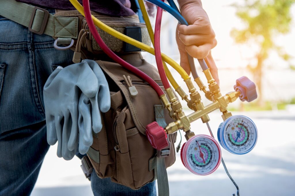 HVAC professional with tool belt and equipment