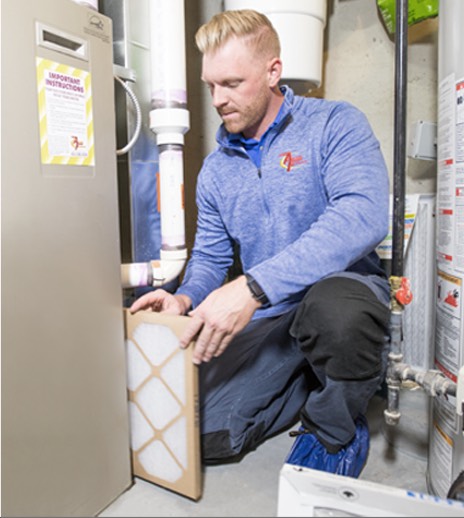 Action Furnace tech replacing an old furnace filter