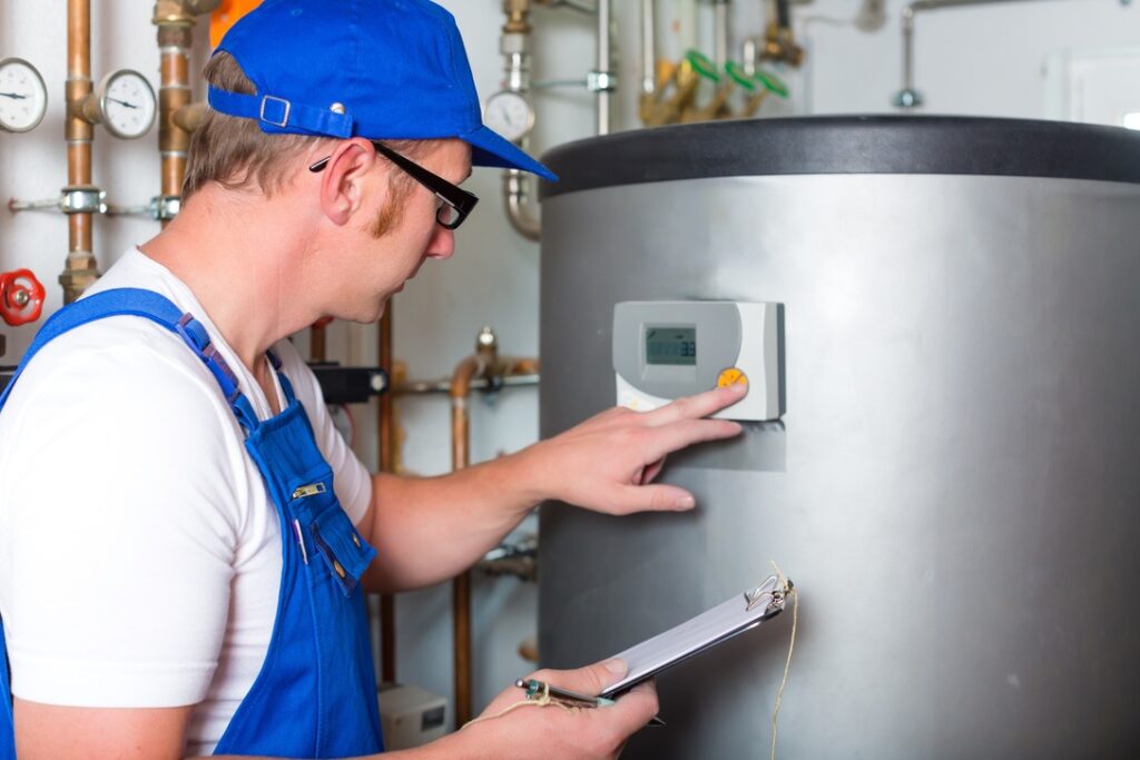 Professional technician turning off water heater tank in home