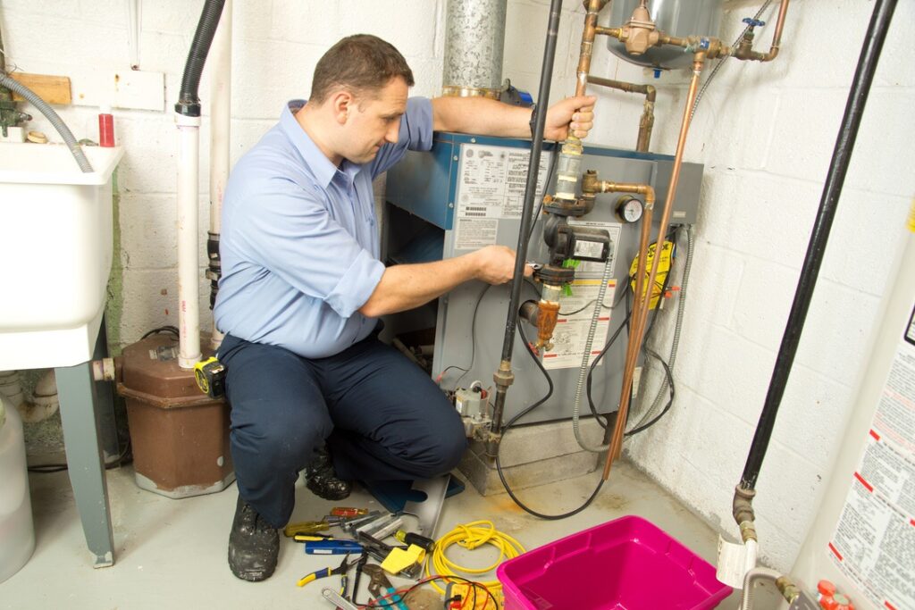 Technician repairing old furnace with potentially expensive fix