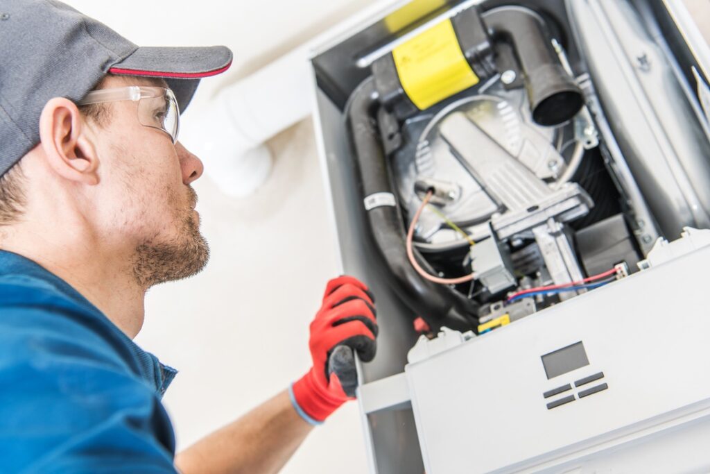 HVAC technician performing furnace maintenance on new model