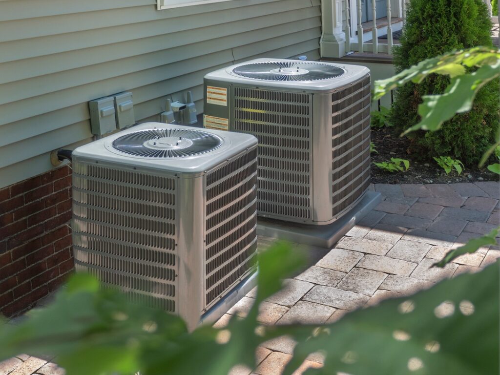 Outdoor units of central AC systems outside homes in Alberta