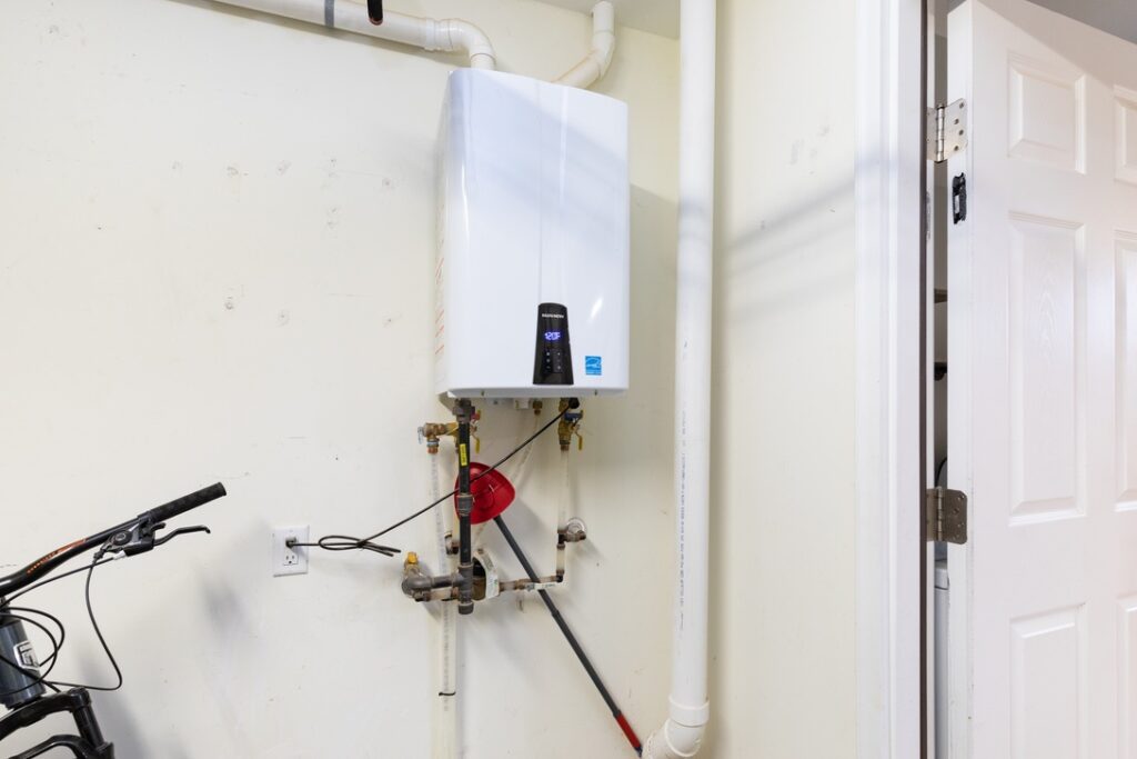Tankless hot water heater in garage of home
