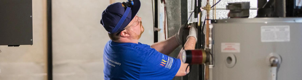 An Action Furnace technician performing maintenance on an HVAC system in a residential setting.