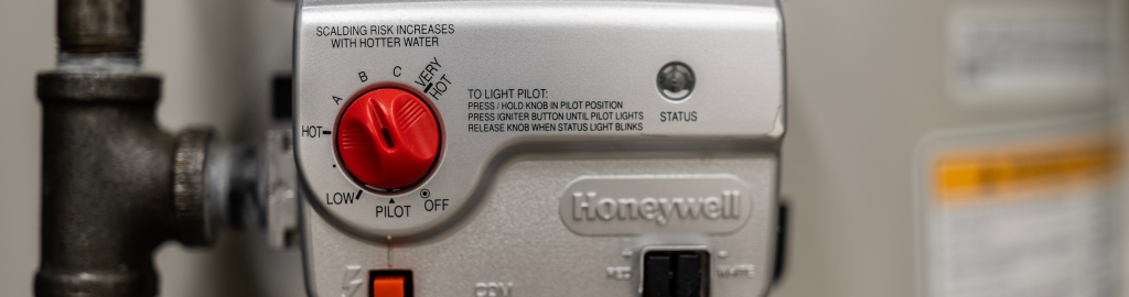 A close up image of a hot water tank's thermostat and controls.