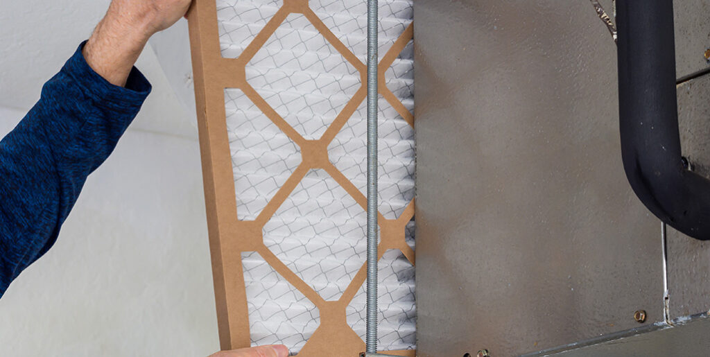 Ways to Make Your Air Conditioner Last Longer Tech replacing air filter;