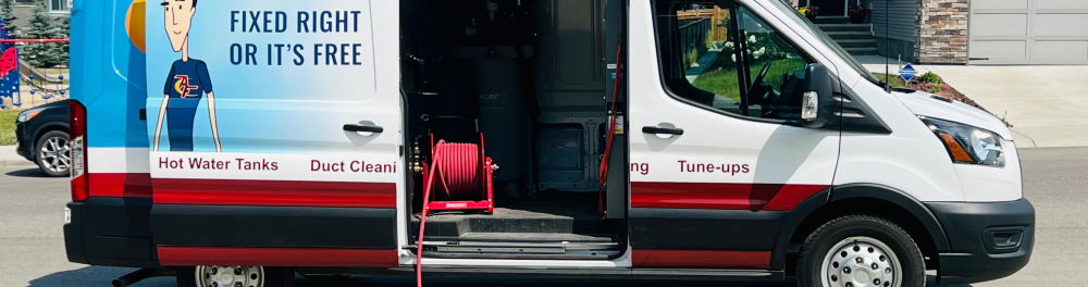An Action Furnace truck parked along a residential street. The door is open showing the vacuum hose and other duct cleaning equipment inside.
