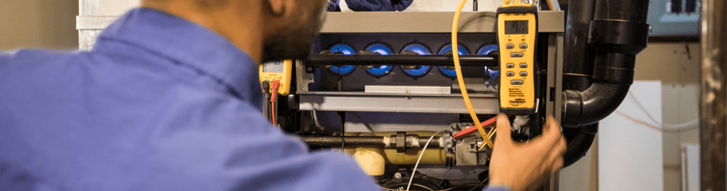 A furnace technician reads the data being displayed on his equipment.