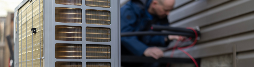 An Action Furnace technician carefully inspects a heat pump's connections to the home.