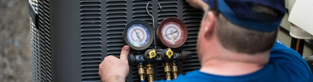 An Action Furnace technician runs a diagnostic check on a central air conditioner.